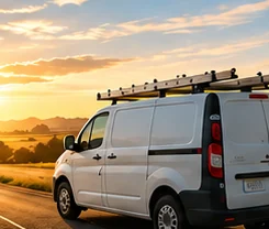 Service van with a roof ladder rack parked on a country road
